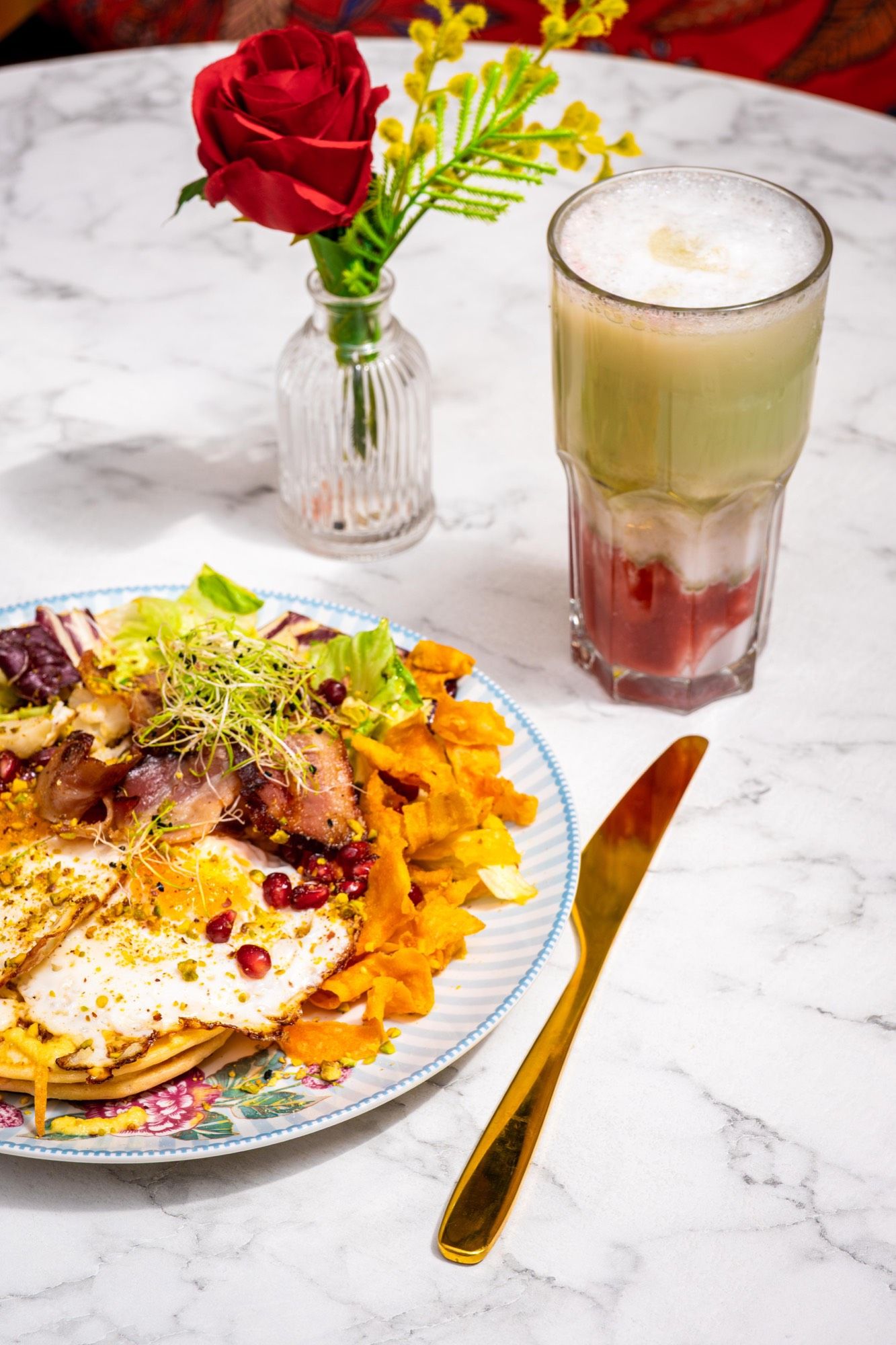 Assiette salée du brunch — œuf au plat, bacon et chips de patate douce — avec un strawberry matcha