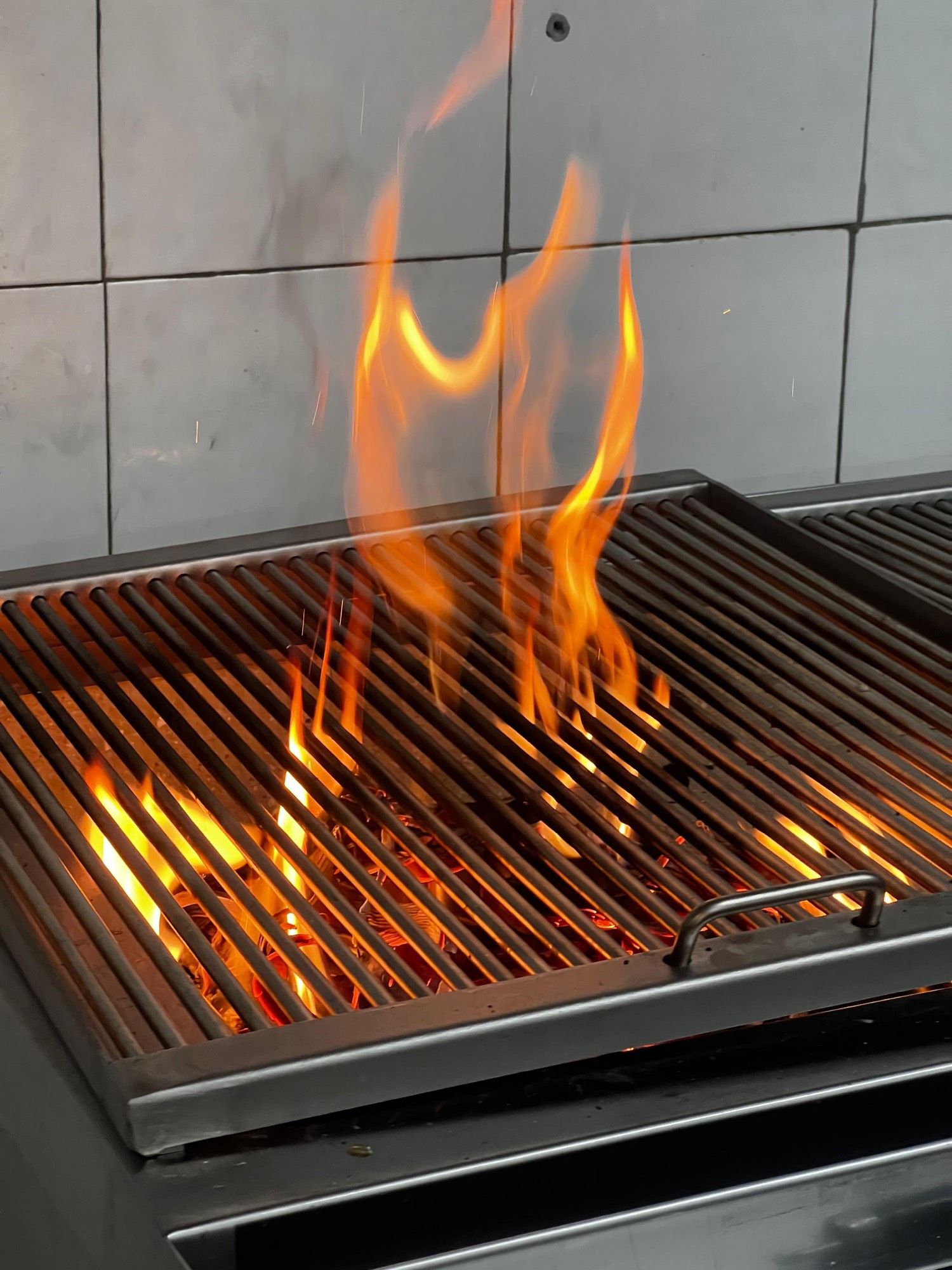Flamme jaillissant du grill au charbon de bois de PEACH