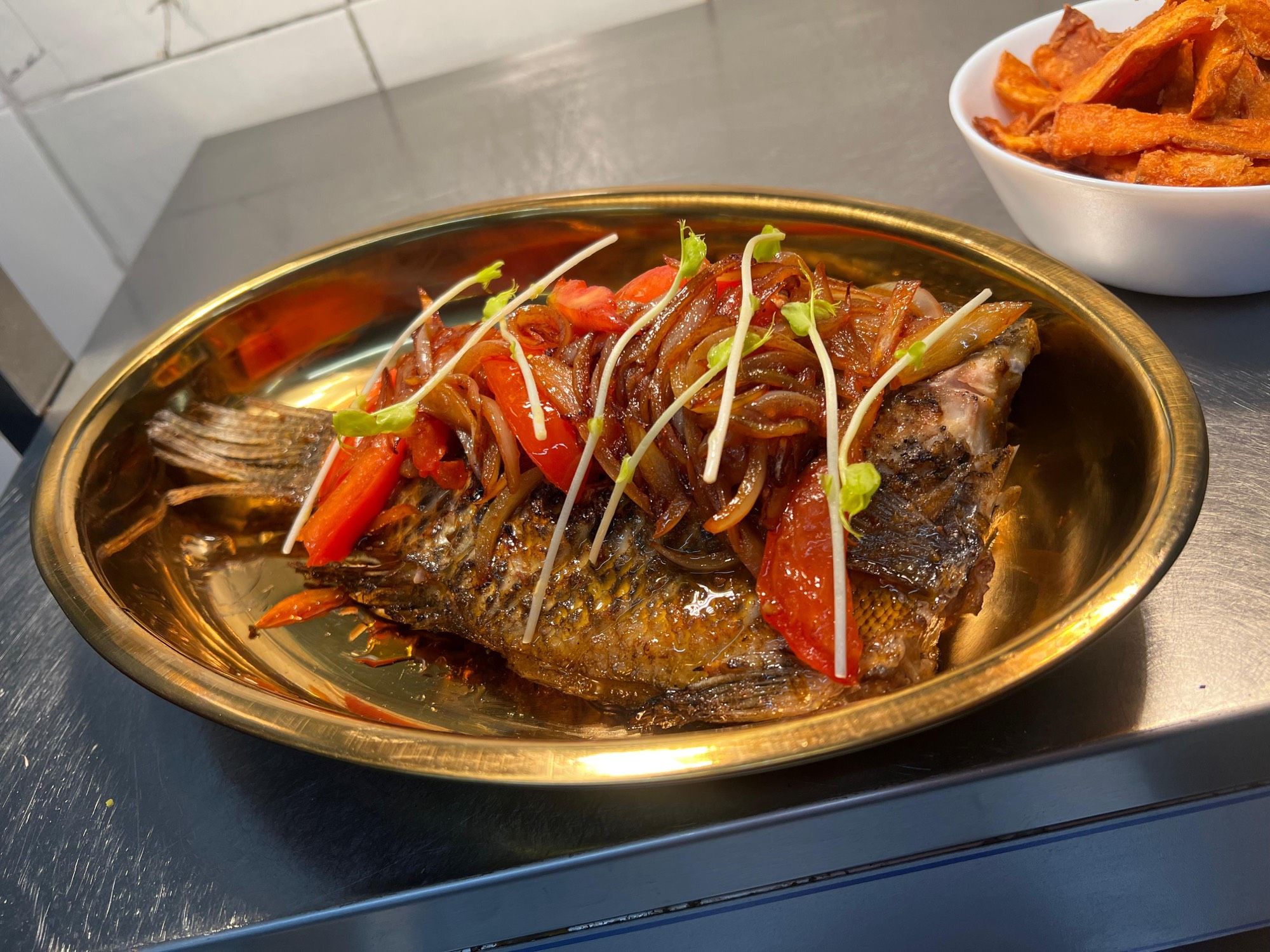Tilapia braisé et frites de patate douce dressés chez PEACH — prêts à partir en livraison ou à emporter